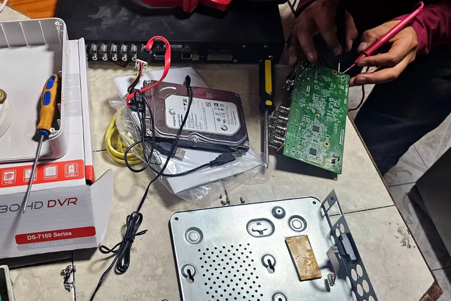Técnico de Climatiselektric reparando la tarjeta de un grabador DVR Hikvision para cámaras de seguridad